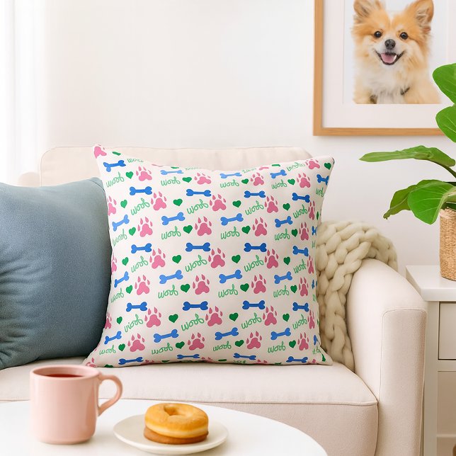 Dog Bone Woof Pink Blue Green Pattern Throw Pillow (A throw pillow with a pattern of pink dog paws, blue bones and green woofs.)
