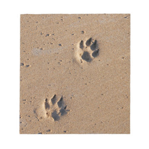 Dog paw prints on a sandy beach notepad