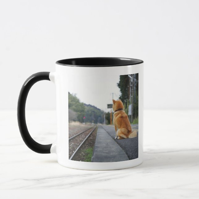 Dog sitting on train station mug (Left)