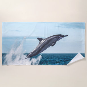Dolphin leaping out of the ocean beach towel