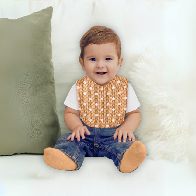 Dotty Delight Orange Baby Bib (A baby wears a Dotty Delight Orange Baby Bib. )