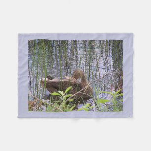 Duck preening itself among the reeds Fleece Blanket