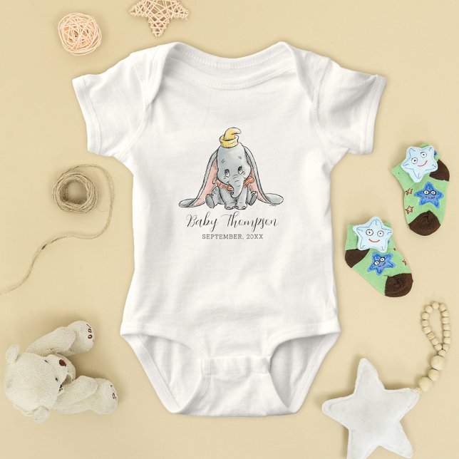 Dumbo Watercolor Announcement Date Baby Bodysuit (Bodysuit on table with baby toys)