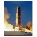 Earth Shakes as Saturn V Blazes Skyward to Moon Cutout<br><div class="desc">The Earth trembled beneath the colossal thrust of the Saturn V. Buildings swayed precariously as a torrent of flame and fury roared heavenward. The launchpad became a cauldron of churning smoke, momentarily obscuring the behemoth clawing its way towards the inky blackness of space, carrying humanity's dreams on its fiery breath....</div>