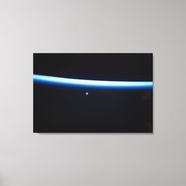 Earth's Thin Line Of Atmosphere And A Gibbous Moon Canvas Print (Front)