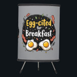 Egg-cited for Breakfast Funny Foodie Pun Design Tripod Lamp<br><div class="desc">Start your morning with a smile with this playful "Egg-cited for Breakfast" design, perfect for food lovers and brunch enthusiasts alike. Featuring a charming hand-drawn style, this artwork showcases two sunny-side-up eggs alongside crispy bacon strips, all set against a whimsical backdrop of scattered seasonings and vibrant typography. The warm yellow...</div>
