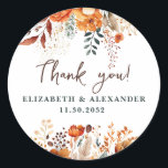 Elegant autumnal floral names and wedding date classic round sticker<br><div class="desc">These romantic and elegant autumnal floral Thank-you stickers make the perfect seal for your wedding favor, presenting a chic botanical design that features a classy watercolor illustration of flowers and greenery in warm fall tones and is easily customizable with your names and wedding date. These stickers are part of the...</div>