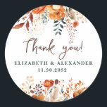 Elegant autumnal floral names and wedding date classic round sticker<br><div class="desc">These romantic and elegant autumnal floral Thank-you stickers make the perfect seal for your wedding favor, presenting a chic botanical design that features a classy watercolor illustration of flowers and greenery in warm fall tones and is easily customizable with your names and wedding date. These stickers are part of the...</div>