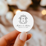 Elegant Black Chinoiserie Crest Monogram Wedding Classic Round Sticker<br><div class="desc">Enhance your wedding details with our Elegant Black Chinoiserie Monogram Crest wedding stickers. Featuring a beautiful black baroque-style crest surrounding the couple's monogram, these stickers display names in classic black calligraphy with the wedding date below. Perfect for sealing envelopes, decorating party favors, and adding a personalized touch to your celebration....</div>