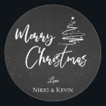 Elegant Chalkboard Script Merry Christmas Tree Classic Round Sticker<br><div class="desc">Elegant Chalkboard Script Merry Christmas Tree Classic Round Sticker. Customize it by changing the names  . The design has Merry Christmas written in pretty font on a chalkboard background along with the names of the couple.  For any further customization ,  feel free to contact me at mypaperlove2021@gmail.com</div>
