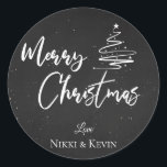 Elegant Chalkboard Script Merry Christmas Tree Classic Round Sticker<br><div class="desc">Elegant Chalkboard Script Merry Christmas Tree Classic Round Sticker. Customize it by changing the names  . The design has Merry Christmas written in pretty font on a chalkboard background along with the names of the couple.  For any further customization ,  feel free to contact me at mypaperlove2021@gmail.com</div>