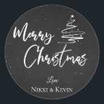 Elegant Chalkboard Script Merry Christmas Tree Classic Round Sticker<br><div class="desc">Elegant Chalkboard Script Merry Christmas Tree Classic Round Sticker. Customize it by changing the names  . The design has Merry Christmas written in pretty font on a chalkboard background along with the names of the couple.  For any further customization ,  feel free to contact me at mypaperlove2021@gmail.com</div>
