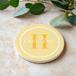 Elegant Golden Yellow Custom Monogram Initial Coaster<br><div class="desc">Elegant round personalized beverage drink coaster design features a classic custom serif monogram initial in a sunny golden marigold yellow color with your last name in modern white calligraphy script against a light yellow colored background. A simple white circle frames the design. Color scheme can be customized to coordinate perfectly...</div>