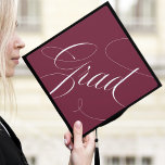 Elegant Grad Calligraphy Script Burgundy Graduation Cap Topper<br><div class="desc">Chic and stylish graduation cap topper featuring "Grad" in a modern calligraphy script against a maroon background. Change the background color and add text with the Customize tool.</div>