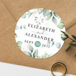 Elegant greenery eucalyptus names and wedding date classic round sticker<br><div class="desc">This romantic and elegant floral wedding round sticker makes the perfect seal for your wedding favor, presenting a chic botanical design that features a classy bouquet of light and airy watercolor greenery and eucalyptus leaves complemented with glittery golden speckles (printed) and is easily customizable with your names and wedding date....</div>