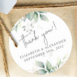 Elegant greenery eucalyptus names and wedding date classic round sticker<br><div class="desc">These romantic and elegant floral Thank you stickers make the perfect seal for your wedding favor, presenting a chic botanical design that features a classy bouquet of light and airy watercolor greenery and eucalyptus leaves complemented with glittery golden speckles (printed) and is easily customizable with your names and wedding date....</div>