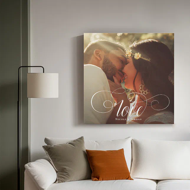 A photo print is placed on a light grey wall over a white couch with a lamp to the left. 