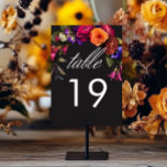 Elegant Moody Vibrant Harvest Floral Table Number<br><div class="desc">Embrace the opulent beauty of a fall floral harvest with our captivating wedding details enclosure card. A dramatic, yet soft black background provides the perfect canvas for a breathtakingly realistic bouquet. Imagine a vibrant explosion of color, featuring roses in orange and dark magenta, with small magenta pink flowers and purple...</div>
