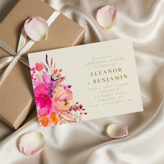 A rehearsal dinner invitation with a bright floral theme. A colorful bouquet of flowers is on the left-hand side of the invite, and a wrapped present is underneath the invite.