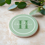 Elegant Sage Green Custom Monogram Initial Coaster<br><div class="desc">Elegant round personalized beverage drink coaster design features a classic custom serif monogram initial in leafy foliage green with your last name in modern white calligraphy script against a sage green background. A simple white circle frames the design. Color scheme can be customized to coordinate perfectly with your home decor....</div>