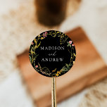 Elegant Summer Wildflower Wreath Black Wedding Classic Round Sticker<br><div class="desc">Elegant wildflower wedding stickers featuring your names displayed in dark gray lettering surrounded by a wreath of green foliage and flowers in shades of golden yellow,  pink,  and purple with a black background. The watercolor wildflower stickers are perfect for spring and summer weddings.</div>
