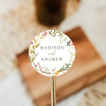 Elegant Summer Wildflower Wreath Wedding Classic Round Sticker<br><div class="desc">Elegant wildflower wedding stickers featuring your names displayed in green lettering surrounded by a wreath of green foliage and flowers in shades of golden yellow,  pink,  and purple. The watercolor wildflower stickers are perfect for spring and summer weddings.</div>