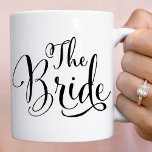 Elegant The Bride Calligraphy Wedding Coffee Mug<br><div class="desc">This stunning wedding mug features The Bride in bold, expressive brush calligraphy that makes a gorgeous statement. The oversized black script on a crisp white background keeps the design minimal and chic. A perfect gift for the bride to be, engagement celebration, bridal shower, or wedding morning. Pair with the matching...</div>