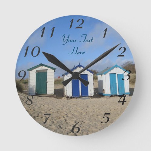 english seaside blue skies and beach huts round clock