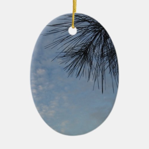 Evergreen Pine Against a Snowy Blue Sky Ceramic Ornament
