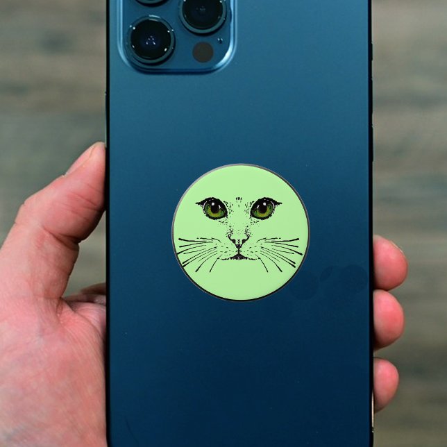 Face of Cat Green Eyes Long Whiskers on Green PopSocket (Black drawing of cat face with long whiskers and green eyes on light green popsocket grip.)