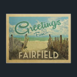 Fairfield Beach Vintage Travel Postcard<br><div class="desc">This Greetings From Fairfield vintage postcard design features a sandy beach with a beautiful turquoise ocean water and above the sea,  a blue sky with billowy white clouds. In vintage travels style.</div>