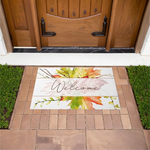 Fall maple leaves with welcome doormat