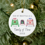 Family of Three | First Christmas Ornament<br><div class="desc">The perfect first Christmas keepsake for your family's first Christmas with your new baby. Our personalized Christmas ornaments feature charming watercolor ugly sweaters family, your family name and is also personalized with your photo on the back. Add your custom wording to this design by using the "Edit this design template"...</div>