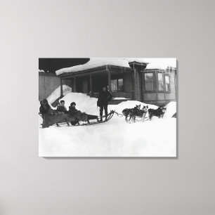 Family traveling by Dog Sled in Alaska Canvas Print