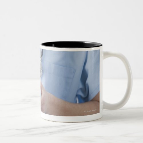 Female doctor holding pill box mid section Two_Tone coffee mug