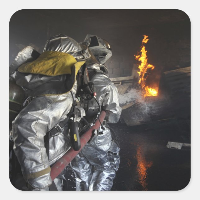 Firefighters extinguish a fire in a training ro square sticker (Front)