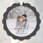 First Christmas Engaged Custom Photo Gray Script Ornament Card<br><div class="desc">Commemorate your engagement with this beautiful keepsake ornament card. The charcoal gray text reads "Our first Christmas engaged, " with the word "engaged" in elegant handwriting script with flourishes before and after. Replace the sample image with your favorite photo, and add your names and the year. A white gradient filter...</div>