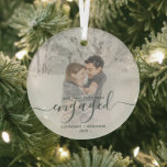 First Christmas Engaged Custom Photo Green Script Glass Ornament<br><div class="desc">Commemorate your engagement with this beautiful modern keepsake ornament. The dark green text reads "Our first Christmas engaged, " with the word "engaged" in elegant handwriting script with flourishes before and after. Replace the sample image with your favorite photo, and add your names and the year. A white gradient filter...</div>