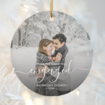 First Christmas Engaged Custom Photo White Script Ceramic Ornament<br><div class="desc">Commemorate your engagement with this beautiful modern keepsake ornament. The white text reads "Our first Christmas engaged, " with the word "engaged" in elegant handwriting script with flourishes before and after. Replace the sample image with your favorite photo, and add your names and the year. A dark gradient filter helps...</div>