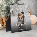 First Christmas Engaged Custom Photo White Script Plaque<br><div class="desc">Commemorate your engagement with this beautiful modern keepsake plaque. The white text reads "Our first Christmas engaged, " with the word "engaged" in elegant handwriting script with flourishes before and after. Replace the sample image with your favorite photo, and add your names and the year. A black gradient filter helps...</div>