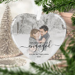 First Christmas Engaged Photo Black Script Heart Ornament<br><div class="desc">Commemorate your engagement with this beautiful heart-shaped keepsake ornament. The black text reads "Our first Christmas engaged, " with the word "engaged" in elegant handwriting script with flourishes before and after. Replace the sample image with your favorite photo, and add your names and the year. A white gradient filter helps...</div>