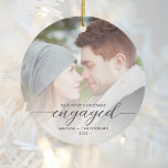 First Christmas Engaged Photo Gray Modern Script Ceramic Ornament<br><div class="desc">Commemorate your engagement with this beautiful modern keepsake ornament. The charcoal gray text reads "Our first Christmas engaged, " with the word "engaged" in elegant calligraphy script with decorative swashes before and after. Replace the sample image with your favorite photo, and add your names and the year. A white gradient...</div>