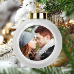 First Christmas Engaged Photo White Modern Ceramic Ball Christmas Ornament<br><div class="desc">Commemorate your engagement with this beautiful modern keepsake ornament. The white text reads "Our first Christmas engaged, " with the word "engaged" in elegant calligraphy script with decorative swashes before and after. Replace the sample image with your favorite photo, and add your names and the year. A dark gradient filter...</div>
