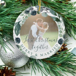 First Christmas merry and married couple photo  Ceramic Ornament<br><div class="desc">Watercolor green foliage eucalyptus greenery leaves wreath and a classy trendy handwritten style calligraphy script making a beautiful modern wedding newlyweds couple photo personalized keepsake Christmas tree ornament template.               Easy to replace the photo with your own! You can change the script text with yours.</div>