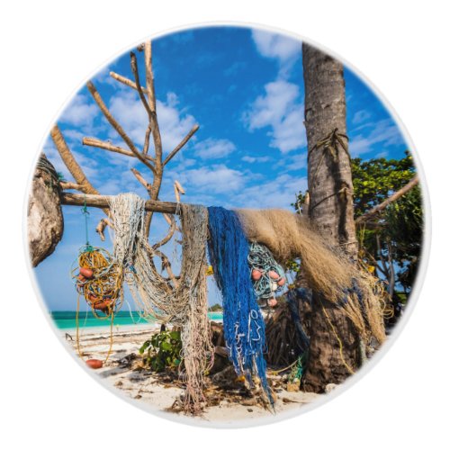 Fishing nets drying on the beach ceramic knob