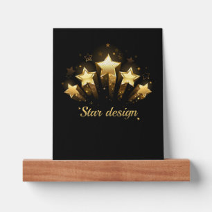 Five gold stars on black picture ledge