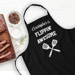 Flippin Awesome Personalized Black Grilling Apron<br><div class="desc">The perfect apron for the chef whose spatula skills are beyond compare, whether flipping burgers on the grill or pancakes on the griddle. Two crossed spatulas appear silhouetted in white under the words "Flippin' Awesome" in white capital letters on a black background. Add his name in retro script. The perfect...</div>