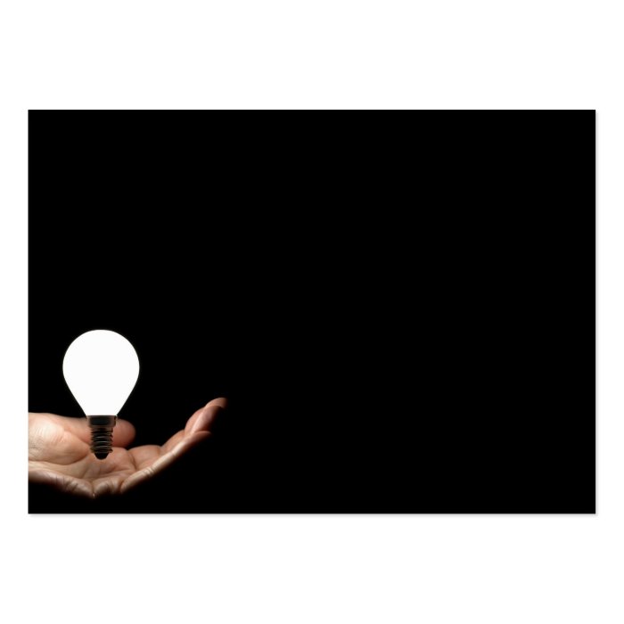 Floating lightbulb above hand on black background business cards