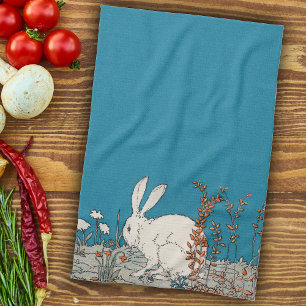 Fluffy White Bunny Sitting in Flowers on Dark Blue Kitchen Towel