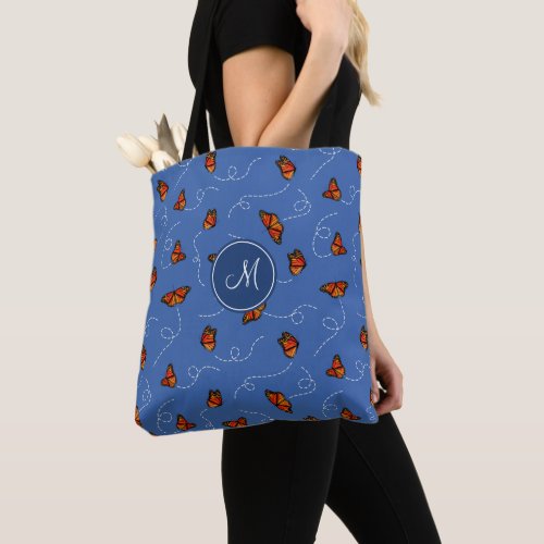 flying Monarch butterflies on blue monogrammed Tote Bag